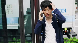 日本学生在电话亭旁边用手机视频素材模板下载