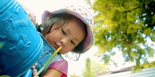 小女孩在花园里给植物浇水\理念:关爱自然