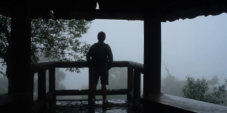 一名徒步旅行者在热带雨林的薄雾中伸展手臂
