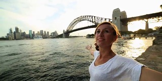 一名年轻女子的肖像在悉尼海港张开双臂