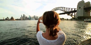 一名女子用心形手指框勾勒出悉尼的天际线