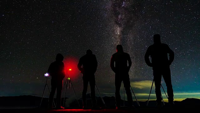 延时长短摄影师拍摄的照片，银河和星迹在夜晚的山。