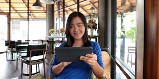 一个女人在咖啡馆里用平板电脑