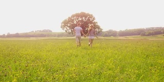 年轻夫妇在草地上奔跑