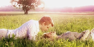 草地上一对浪漫的年轻情侣
