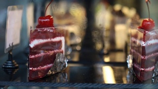 糕饼店蛋糕陈列柜里的红丝绒纸杯蛋糕视频素材模板下载