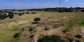 Goldthwaite，德克萨斯州风力农场在德克萨斯州丘陵乡村农场与风力涡轮机在山顶上的背景
