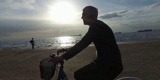 夕阳西下，成熟的女人在海边骑自行车