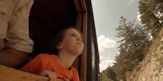 火车上的孩子——一个小女孩享受她的第一次火车旅行。山景窗外