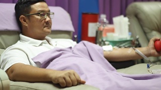 一个年轻人在献血的时候，躺在沙发上休息视频素材模板下载