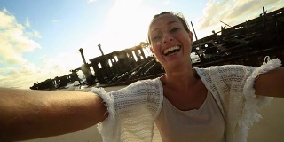 年轻女性站在Maheno沉船附近的自拍照