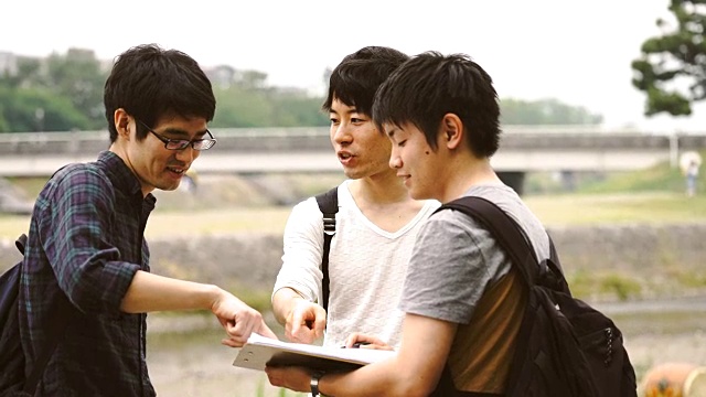 三个年轻的成年学生在户外交谈