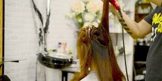 长头发的女人在美容院吹风机