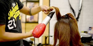 长头发的女人在美容院吹风机