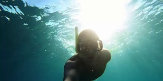 年轻男子戴着浮潜面罩潜水