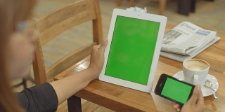 一位女士手持绿屏智能设备
