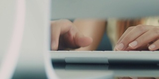 近距离的女人的手在电脑键盘上