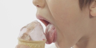 一个男孩舔冰淇淋的特写慢镜头。