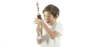 一个混血男孩用慢镜头庆祝他的奖杯。
