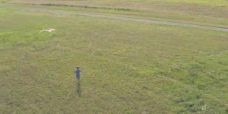 小男孩带着风筝在田野里奔跑