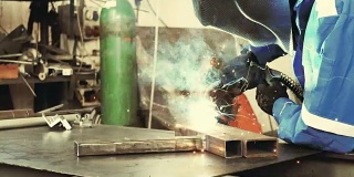 工厂中焊接钢件的焊工