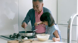 小女孩和她的爷爷一起做饭视频素材模板下载