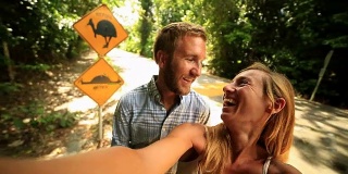 一对澳大利亚夫妇与幽默的食火鸡路标自拍