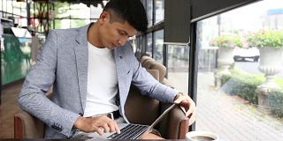 年轻的商人在咖啡店里用平板电脑工作