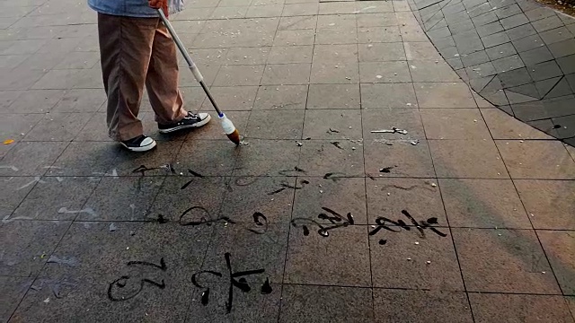用毛笔在地上的广场上写字