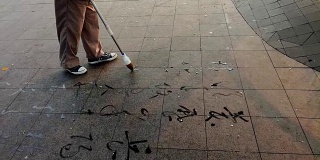 用毛笔在地上的广场上写字