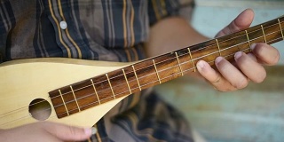 一位音乐家在古老的房子里弹奏曼陀林。