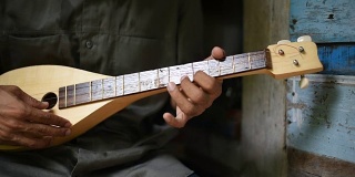 一位音乐家在古老的房子里弹奏曼陀林。
