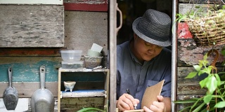 早上，亚洲男人在古董窗边写日记。
