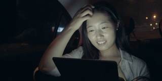 年轻女子在车里看数码平板电脑