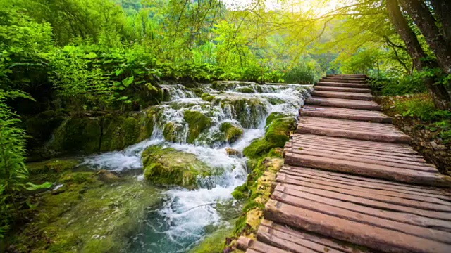 在温暖的阳光下的小瀑布在Plitvice湖国家公园-超级慢镜头