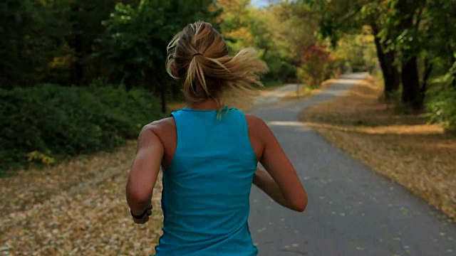 日落时分，年轻女子在公园里跑步