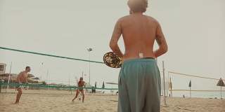 朋友们玩沙滩网球，玩得很开心