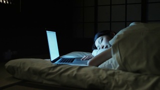 拿着笔记本电脑在床上睡觉的女人视频素材模板下载