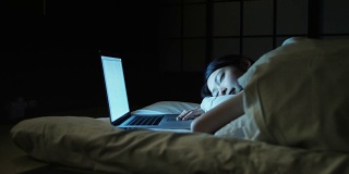 拿着笔记本电脑在床上睡觉的女人