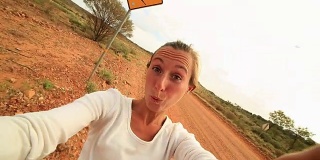 澳大利亚一名年轻女子站在袋鼠标志附近的自拍
