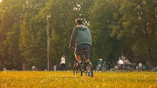 一个在草地上骑自行车的嬉皮士视频素材模板下载