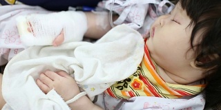 生病的婴儿在医院的安全座椅上接受生理盐水治疗