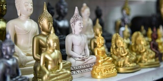 一名泰国游客在纪念品商店选购佛像。