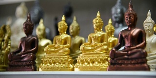 一名泰国游客在纪念品商店选购佛像。