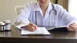 医生用数字平板电脑在剪贴板上写处方药物视频素材模板下载