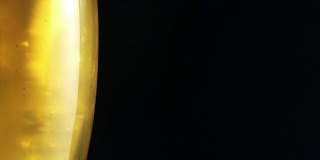 水滴落在装满啤酒的玻璃杯上。新鲜的比喻