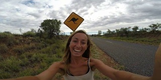 澳大利亚一名年轻女子站在袋鼠标志- 4k附近的自拍