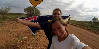 一对年轻夫妇与袋鼠标志自拍，澳大利亚