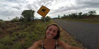澳大利亚一名年轻女子站在袋鼠标志- 4k附近的自拍