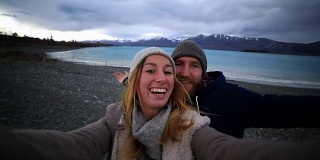 一对年轻夫妇在新西兰的湖岸自拍